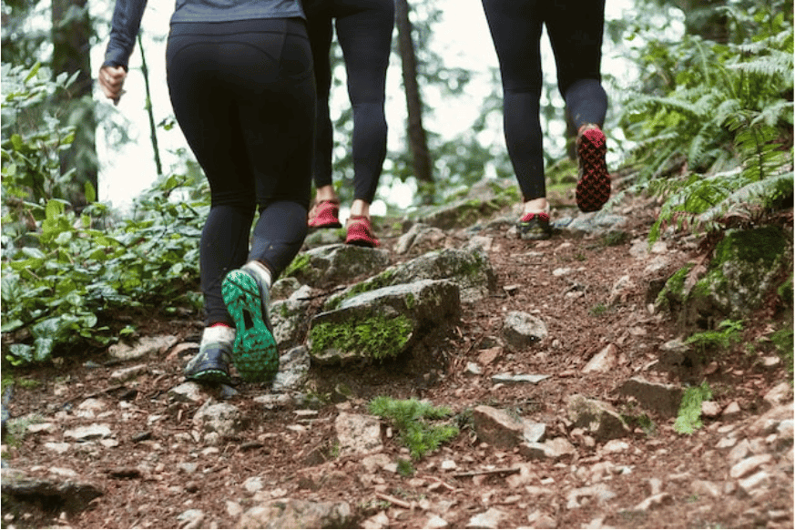 3 women hiking uphill in woods