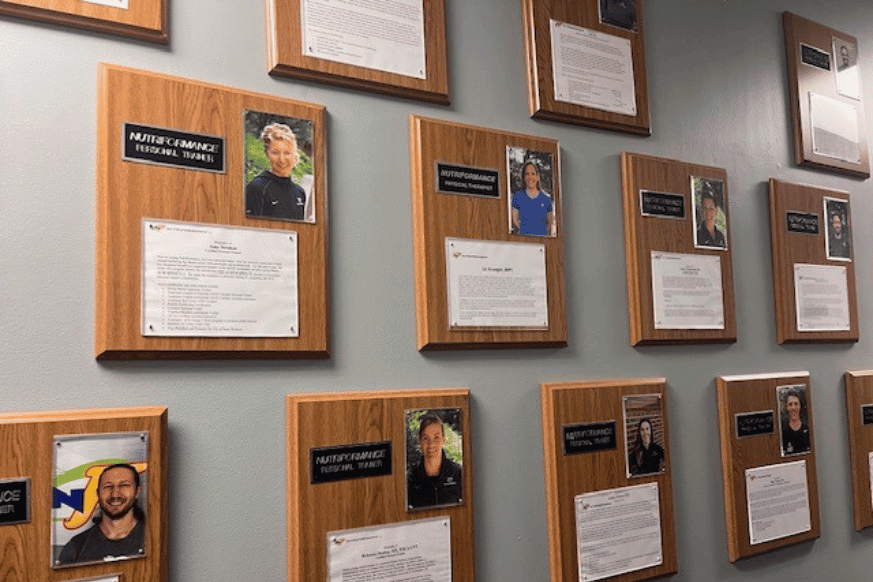 wall of plaques showcasing the dedicated personal trainers at Nutriformance gym