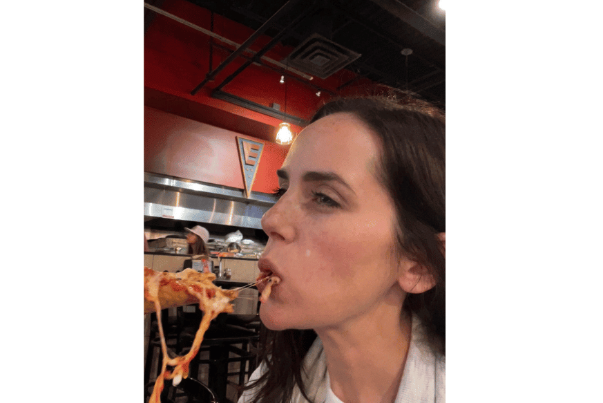 women eating new york style pizza, cheese pull