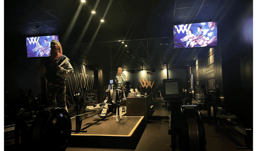 inside the rowing studio at the Row House; lights down, music up, stage for instructor
