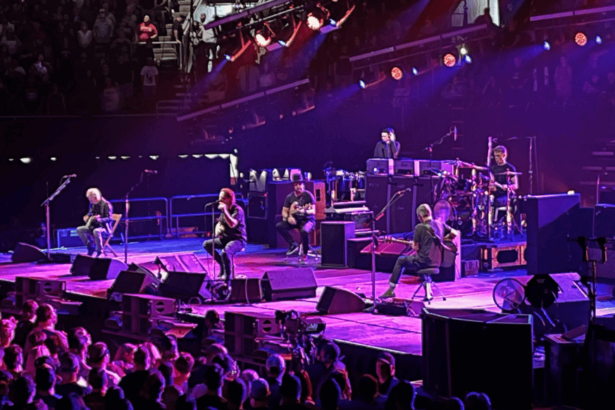 stage at enterprise center with 3 musicians on stage in purple light