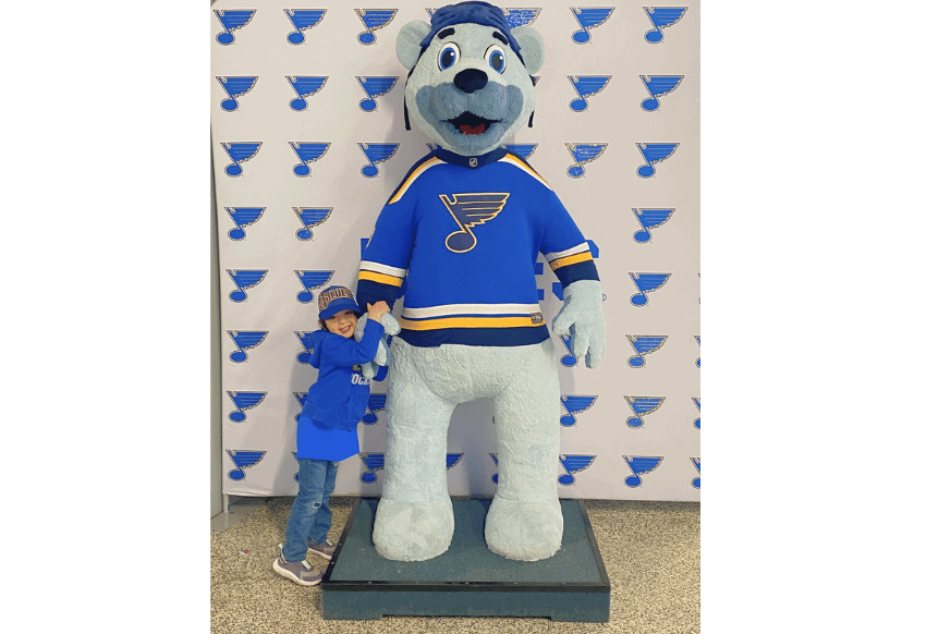 boy posing with st louis mascot. Louie.