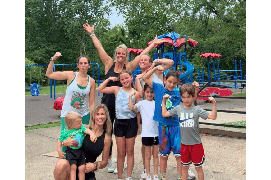 group of moms and kids showing their bicep muscles after a mommy & me workout in st. louis