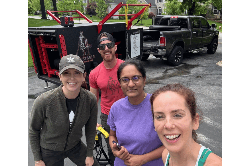 4 people smiling in front of The Stable Mobile Gym