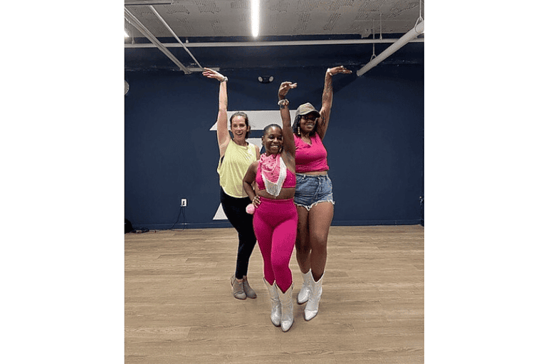 three women wearing athletic cowgirl clothes posing with a hand ofer their head after Urban Line Dancing Class by Her Wellness by Her