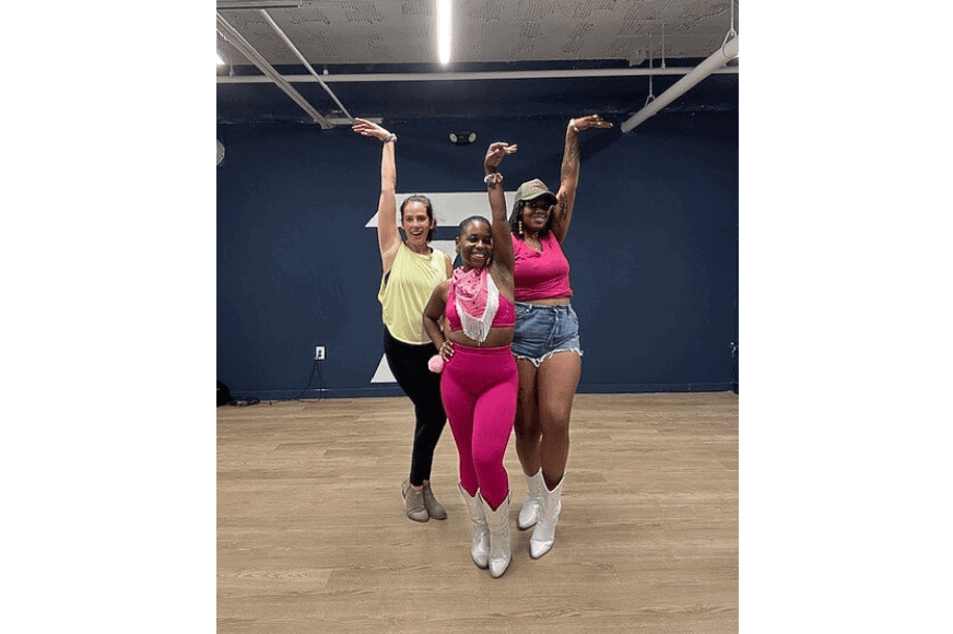 three women wearing athletic cowgirl clothes posing with a hand ofer their head after Urban Line Dancing Class by Her Wellness by Her