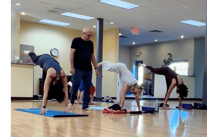emmet coaching his students during a yoga class