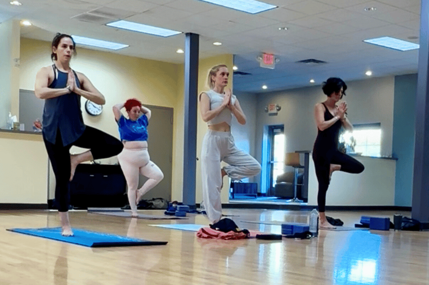 yoga class women doing tree pose