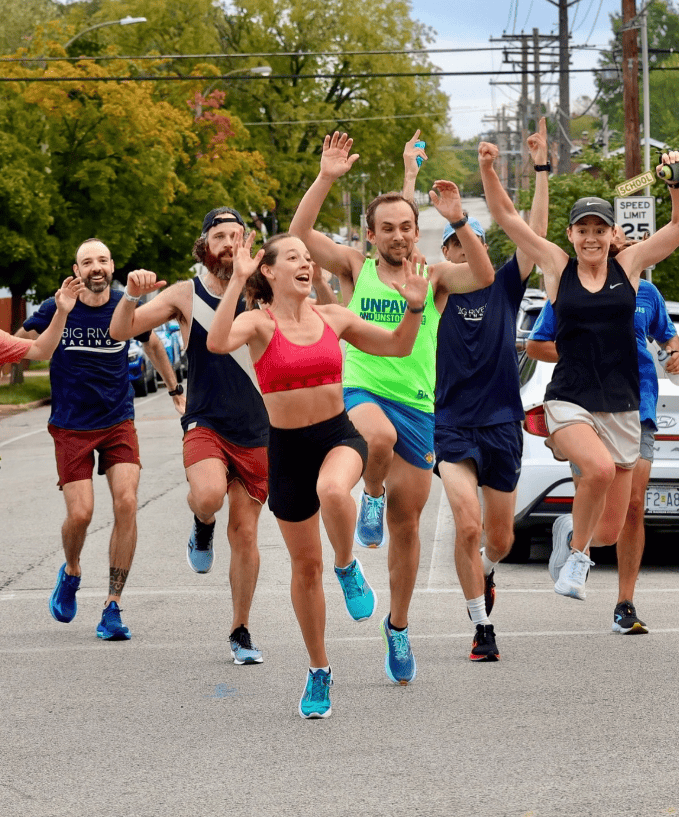 running group happy in the street wearing athletic gear