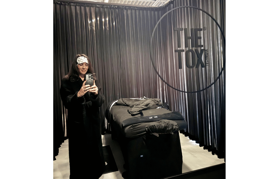 natalie kalmar standing in a treatment room and taking a mirror selfie at the tox wearing an all black robe