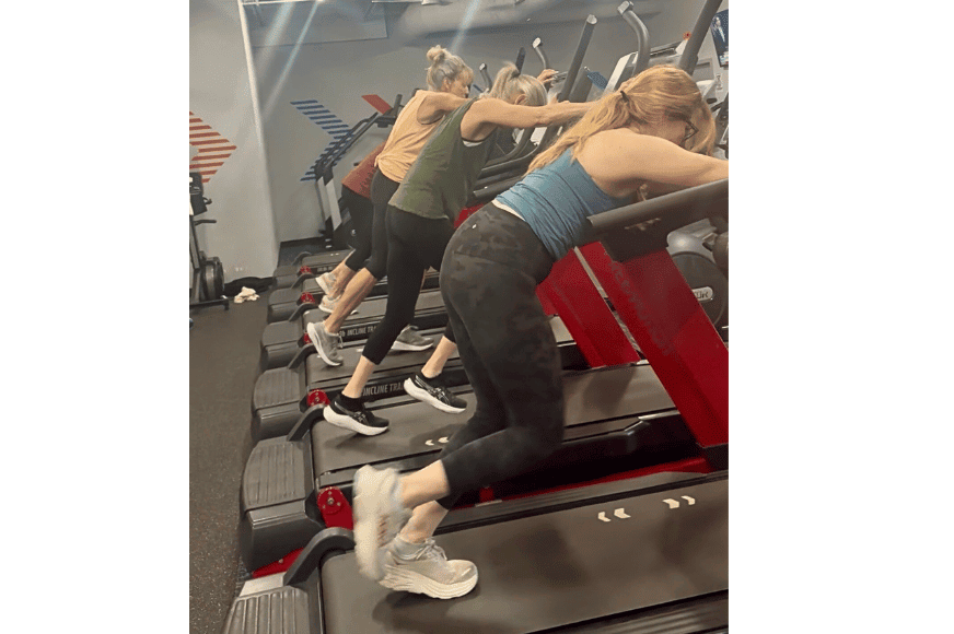 4 women shown hiking on a treadmill with a steep incline, during the hike & hybrid class at nutriformance