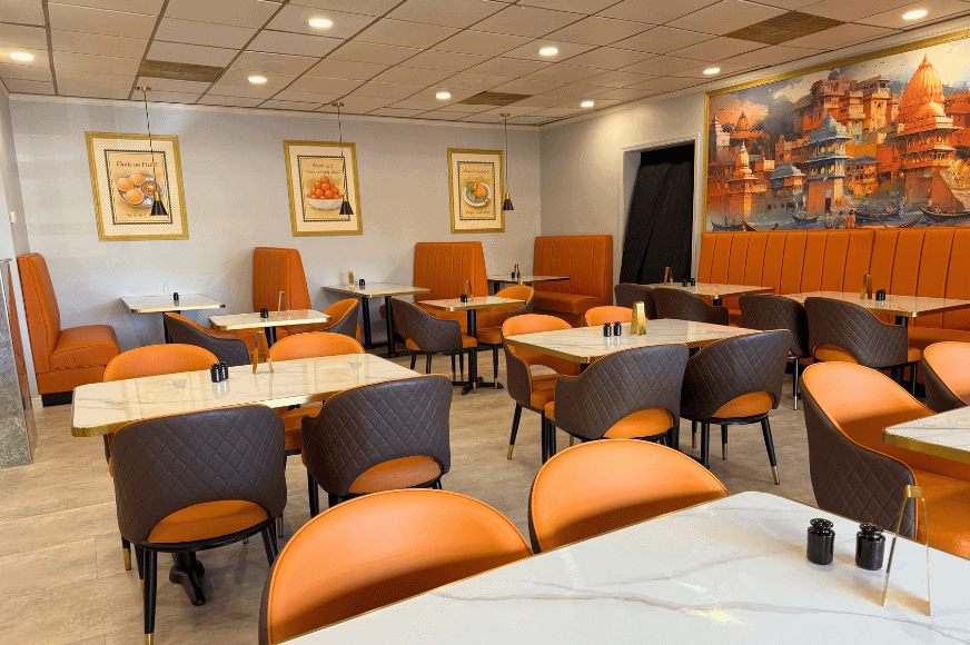 the dining room at persis indian grill in ballwin with upscale orange and brown furnishings, marble and gold accents make the space warm and upscale