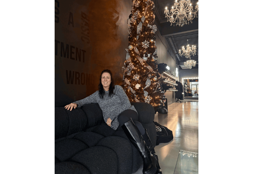 laurie robinson, owner of the tox in chesterfield, is shown sitting on a black couch at the front of the tox in chesterfield. she is shown sitting in front of a decorated Christmas tree