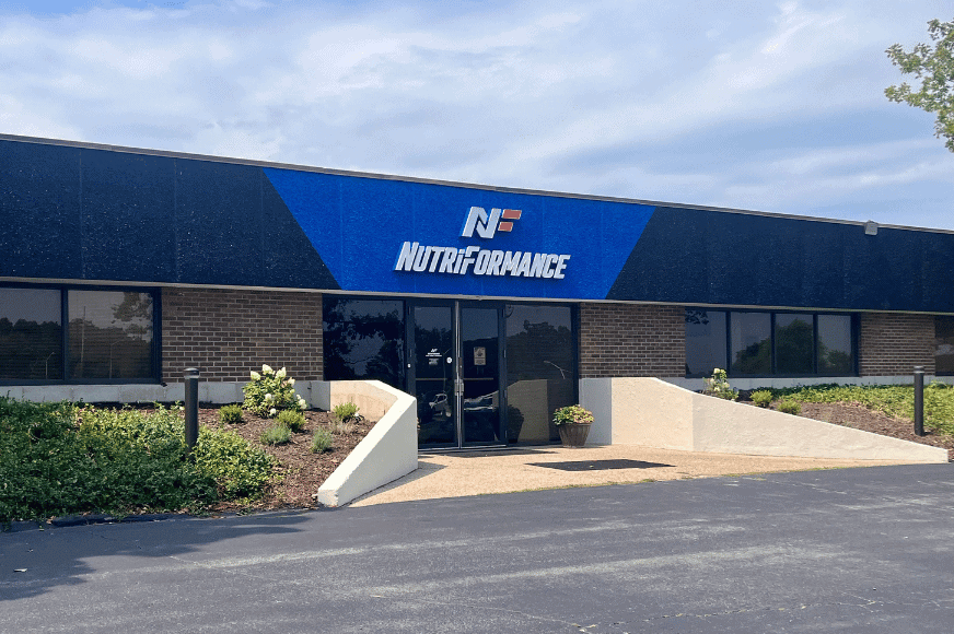 exterior of nutriformance gym, location of many great group fitness classes in st. louis. blue sign with white lettering, clear glass doors