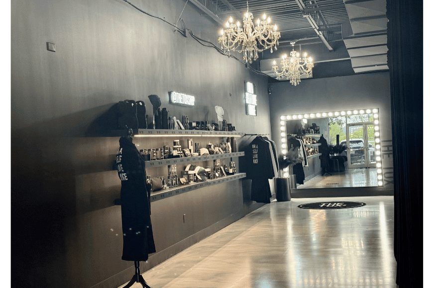white floor and all black studio shown at the tox in chesterfield. on the back wall a large lit mirror draws clients inside