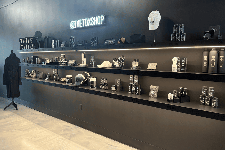 black wall of products at the tox in chesterfield, lots of small items for sale including skincare, and branded merchandise