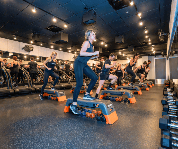shred415 signature group class shows participants divided on black and orange equipment - soe on the floor and some on the treadmill. this class is featured in 3 group fitness classes to know in st. louis.