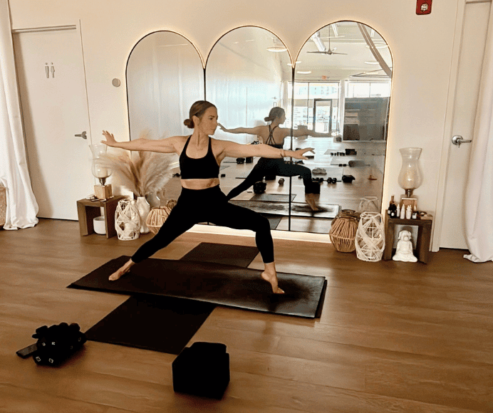 sarah hendricks, owner of warrior won yoga in st louis, holds a warrior 2 pose