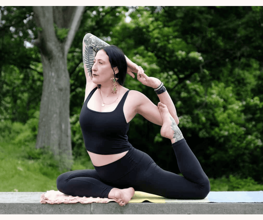 mandi gray outdoor yoga woman wearing all black yoga pants and sports bra holding pose in nature