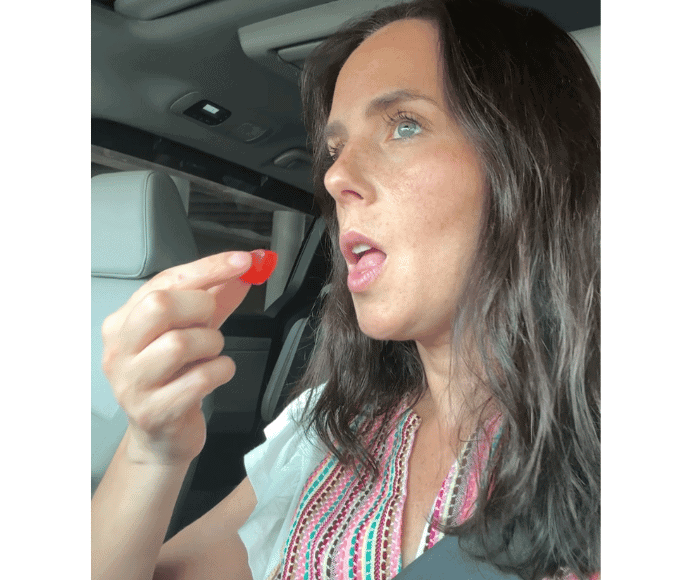 natalie kalmar eating vitatein, a protein gummy, in her car while on the go